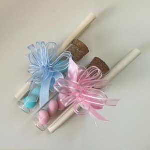 vasetti in vetro con confetti colorati e pergamena per nascita o battesimo