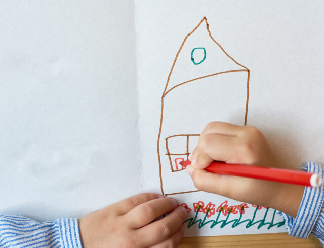 bambino che disegna una casa
