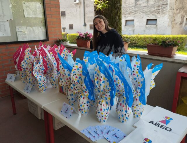 ragazza con tavoli con uova di Pasqua Abeo per una raccolta fondi